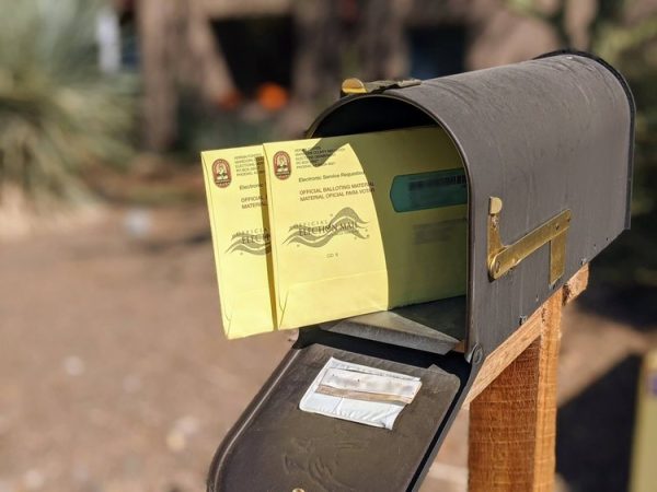 yellow mail-in ballots inside of mailbox