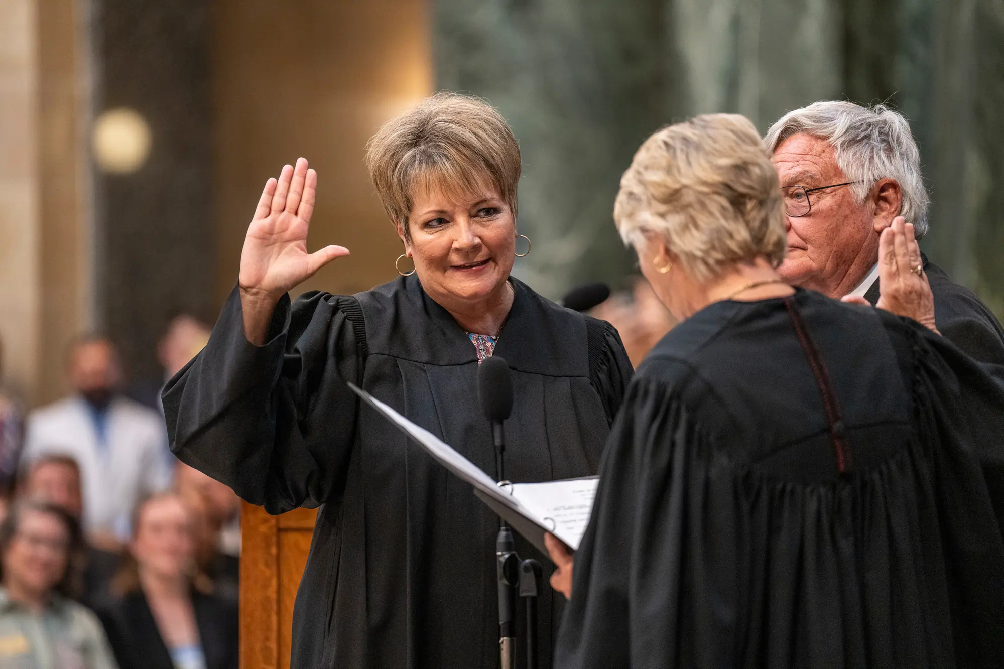 Janet Protasiewicz is raising her hand being sworn in as a State Supreme Court Justice at the Wisconsin State Capitol