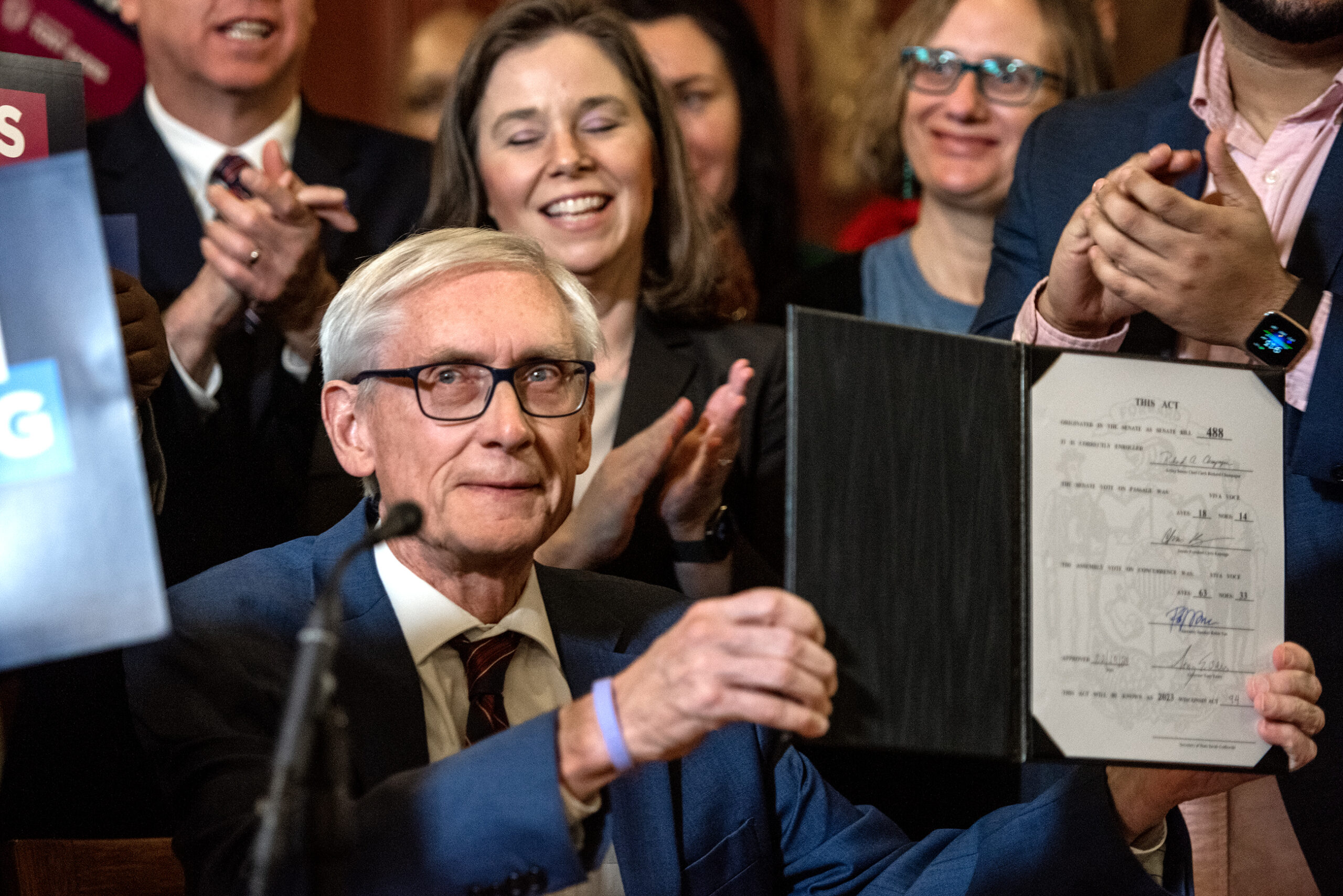 Gov. Tony Evers holds up the bill after signing it Monday, Feb. 19, 2024, at the Wisconsin State Capitol in Madison, Wis.