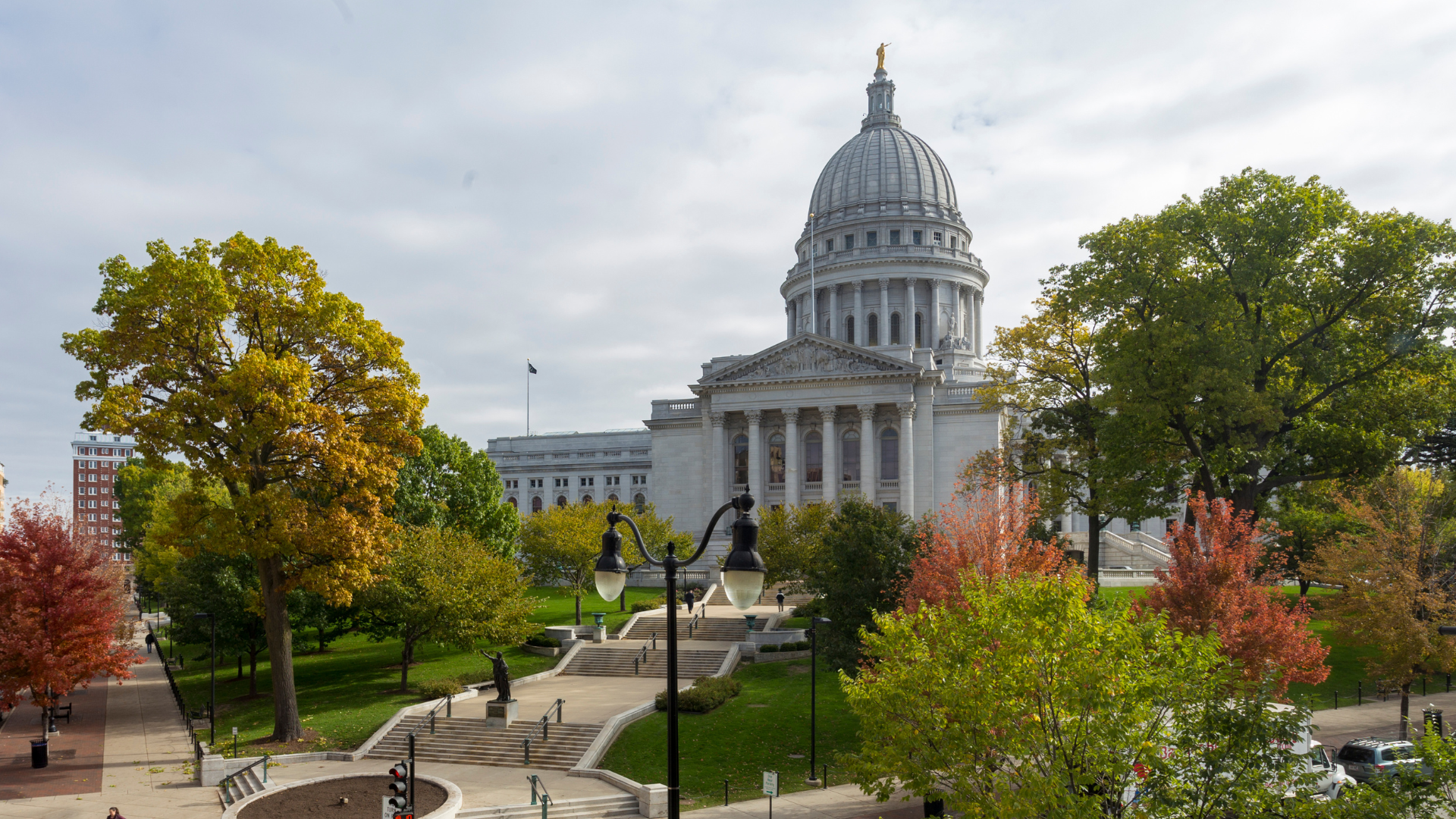 Wisconsin capitol building with fall green, red and yellow leaves on the trees surrounding it